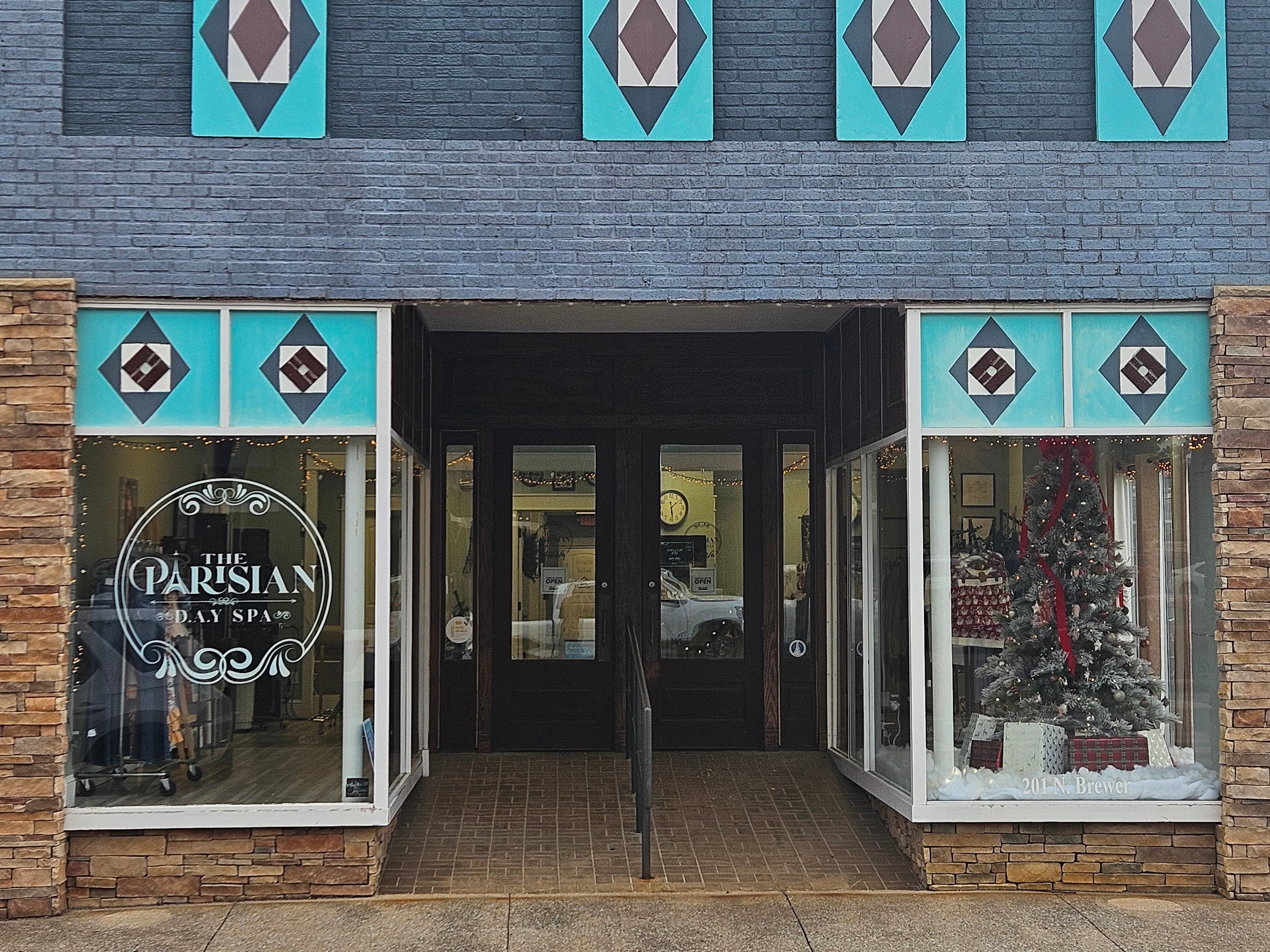 Storefront with decorative elements and a Christmas tree, featuring the 'Parisian' sign.